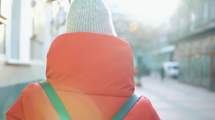 Donna con cappotto rosso e berretto in strada urbana
