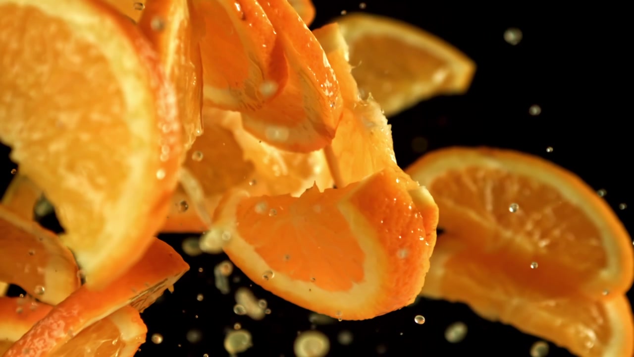 Ferske appelsinskiver med vanndråper som faller i sakte film.