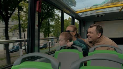 family of tourists traveling by double-decker bus in vienna