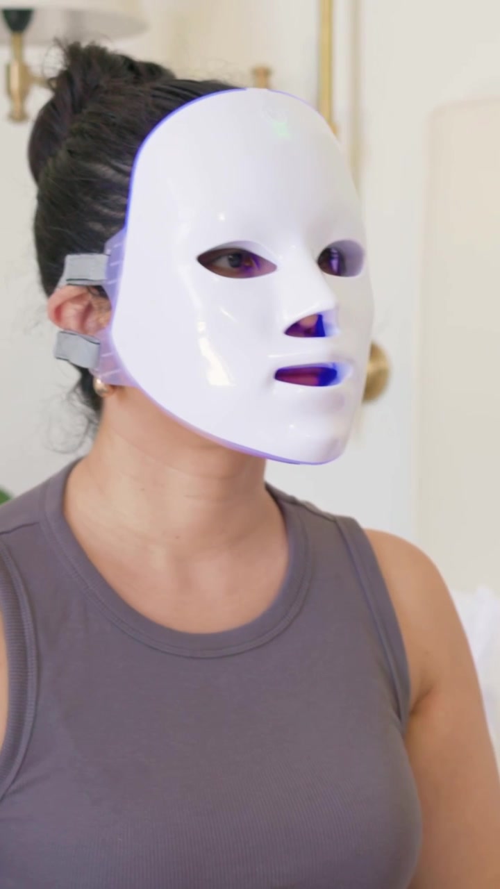 Vertikal video: Kvinde modtager pipette i hånden, placerer LED-maske på sengen og tænder den til hudpleje.