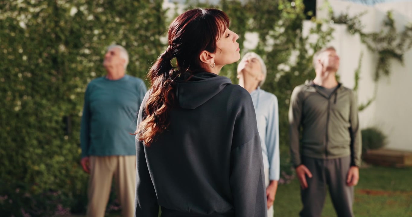 Fitness Instructor Leading Senior Group in Outdoor Stretching Exercise