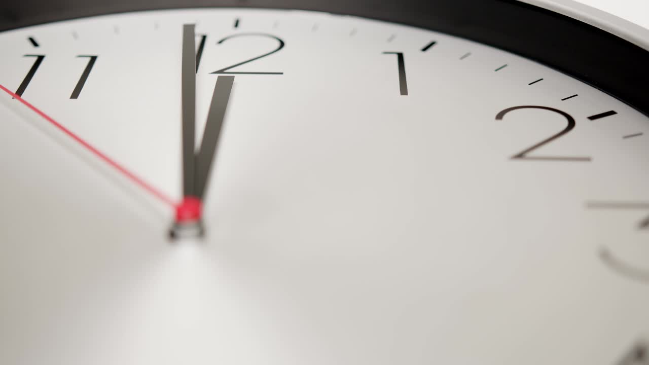 Close up , A white wall clock, one more minute until noon.