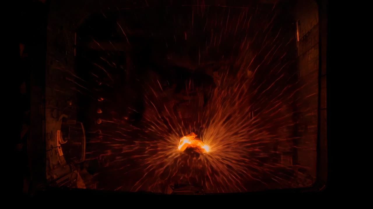 Brightening glowing ember sending growing radial sparks through dark forge opening, latch visible