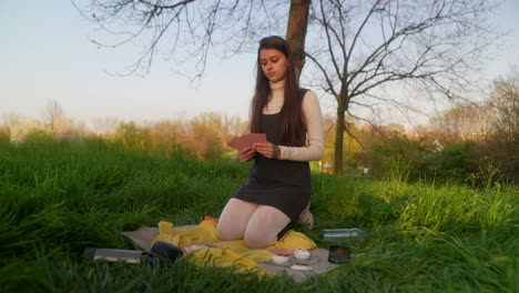 young couple enjoying a picnic and tarot card reading in the park