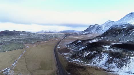 un camino de tierra mojado vacío por las montañas de la isla fantasma en islandia - antena