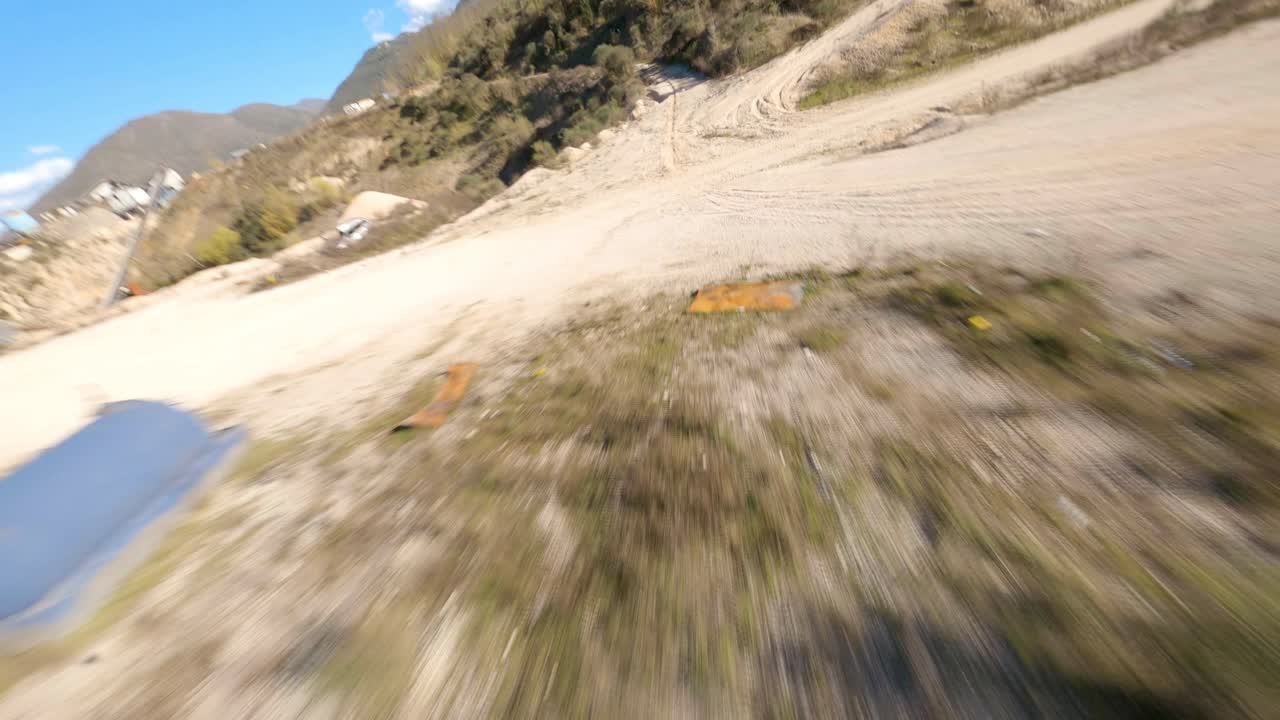 Flying over a dirt road at high speed in an abandoned quarry with an FPV drone