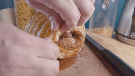 Slow-Motion-Slider-Shot-of-Breaking-a-Piece-of-Crackling-of-a-Roast-Pork-Belly-Joint-on-a-Cutting-Board-in-the-Kitchen