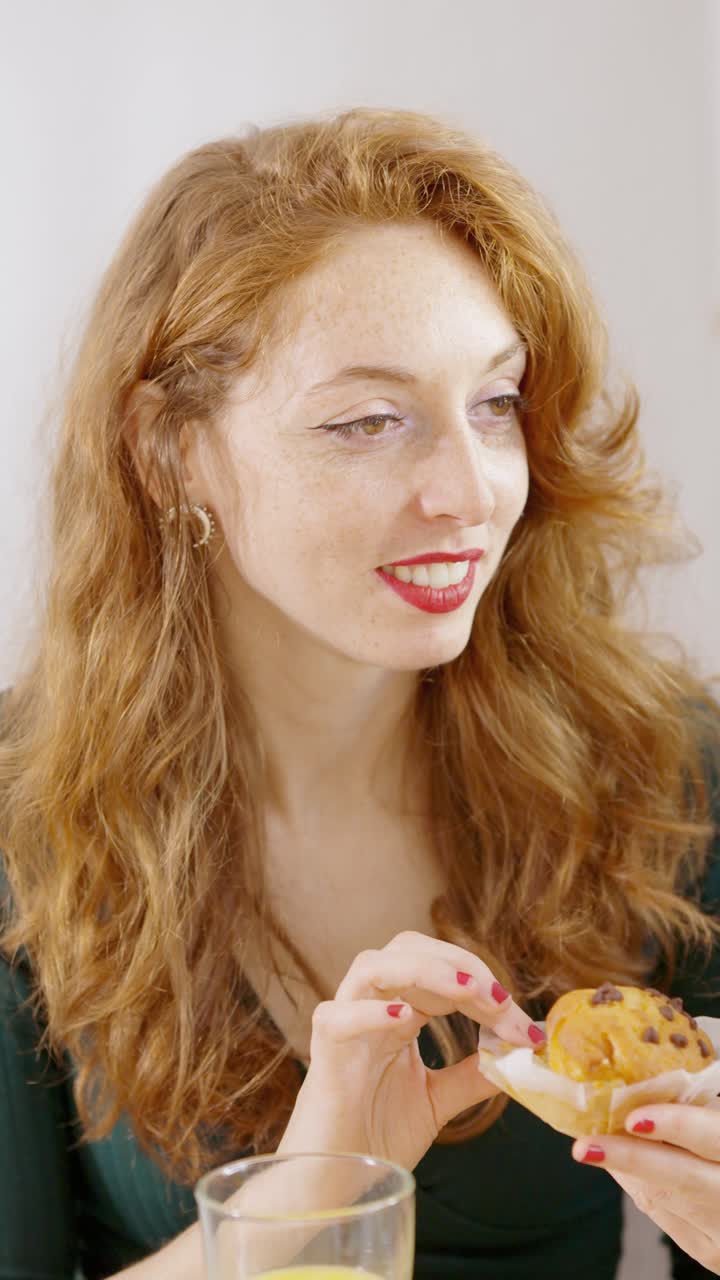 Smiling Woman Enjoying a Muffin and Orange Juice