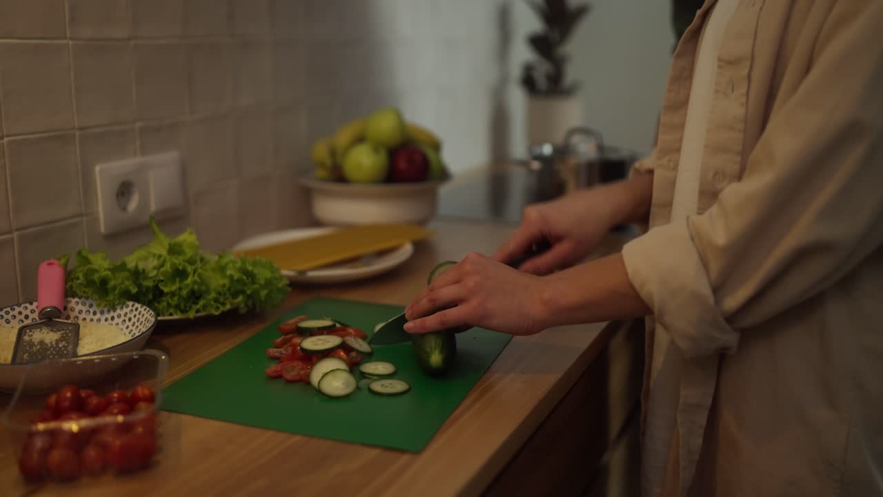 mujer cortando pepinos y tomates para ensalada