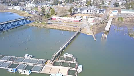 Aerial-Drone-view-over-boat-docks-bridge-and-small-town-on-a-hill