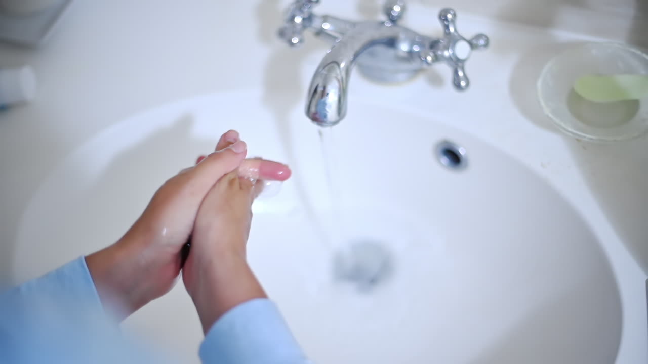 女性が液体石鹸で手を洗う、スローモーション。
