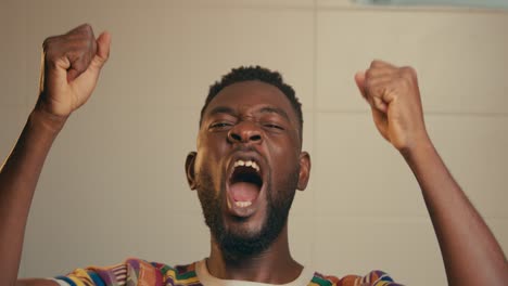 portrait of afro american man wearing kente fabric cloth celebrating joyfully in slow motion