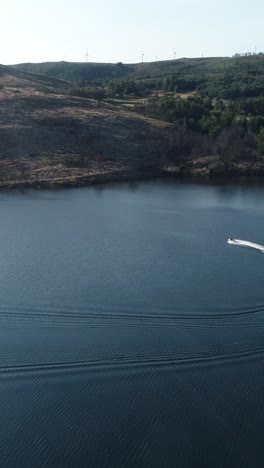 jet skiing on a calm lake with wind turbines in the background