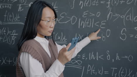 woman explaining math equations on a chalkboard
