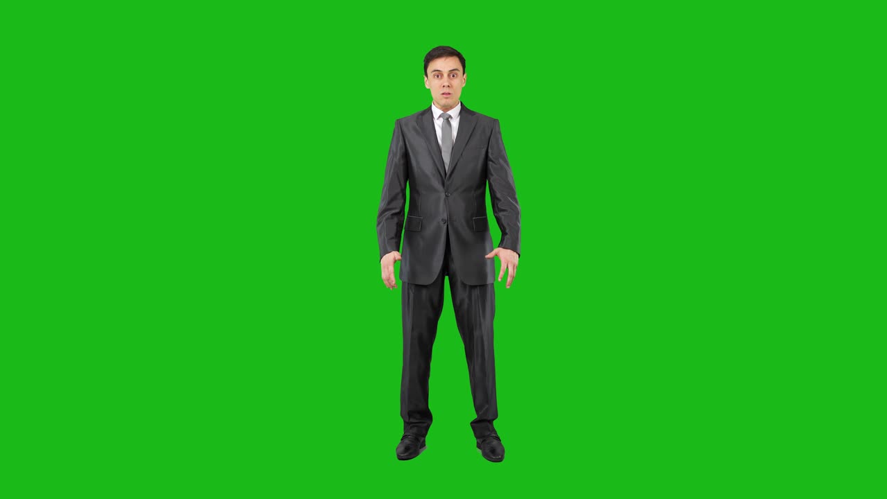 A man in a suit displaying various expressions against a green screen