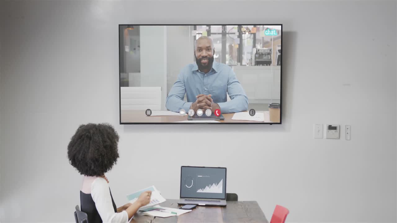 African american businesswoman on video call with african american male colleague on screen
