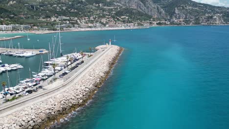 Wellenbrecher-Für-Den-Yachthafen-In-Menton,-Südfrankreich,-Mit-Leuchtturm-Am-Ende,-Luftaufnahme-Eines-Dollys