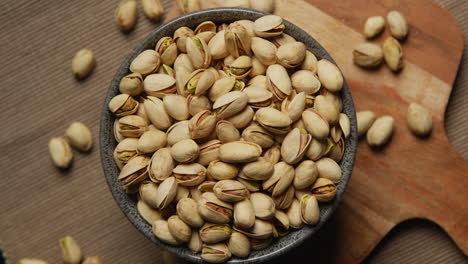 close up overhead shot looking down into bowl containing pistachio nuts revolving