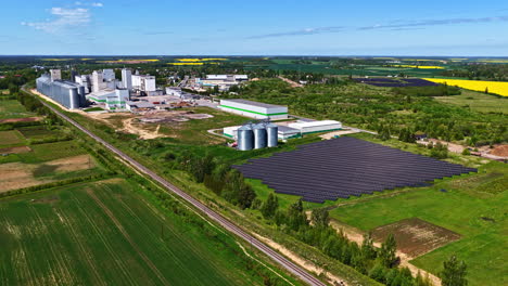 drone video of large industrial facility with solar panel field and farmland