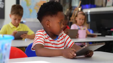 front view of african american schoolboy using digital tablet in the classroom 4k