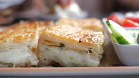 close-up of a traditional turkish breakfast pastry with cheese and herbs