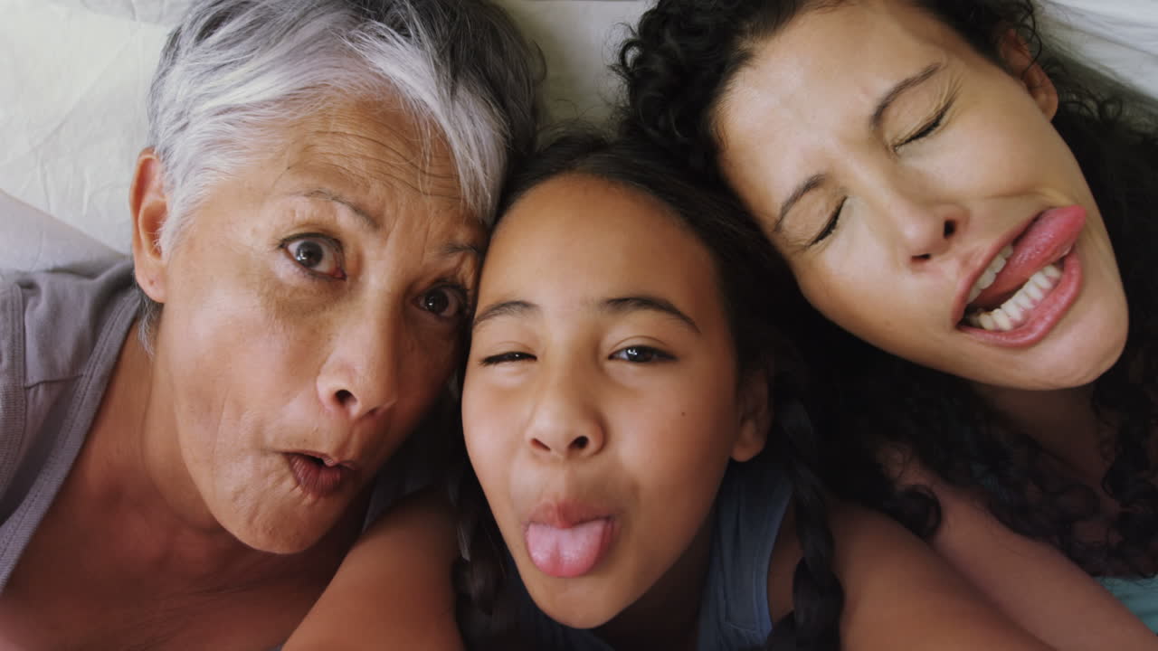 familia feliz acostada en la cama en el dormitorio 4k