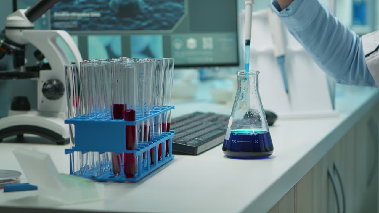 близкий взгляд на ученых, тестирующих образцы жидкости с помощью микропипетки