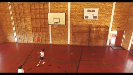 boys playing basketball in court