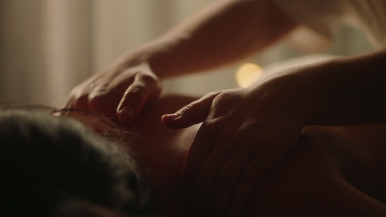 Professionel rygmassage i et dæmpet belyst rum