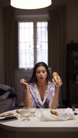 young woman eating a sandwich at home