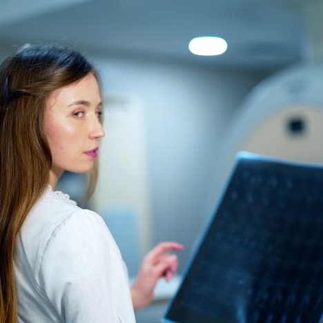 woman doctor with x-ray photo. young female doctor examines radiology scan in advanced hospital. medical concept.