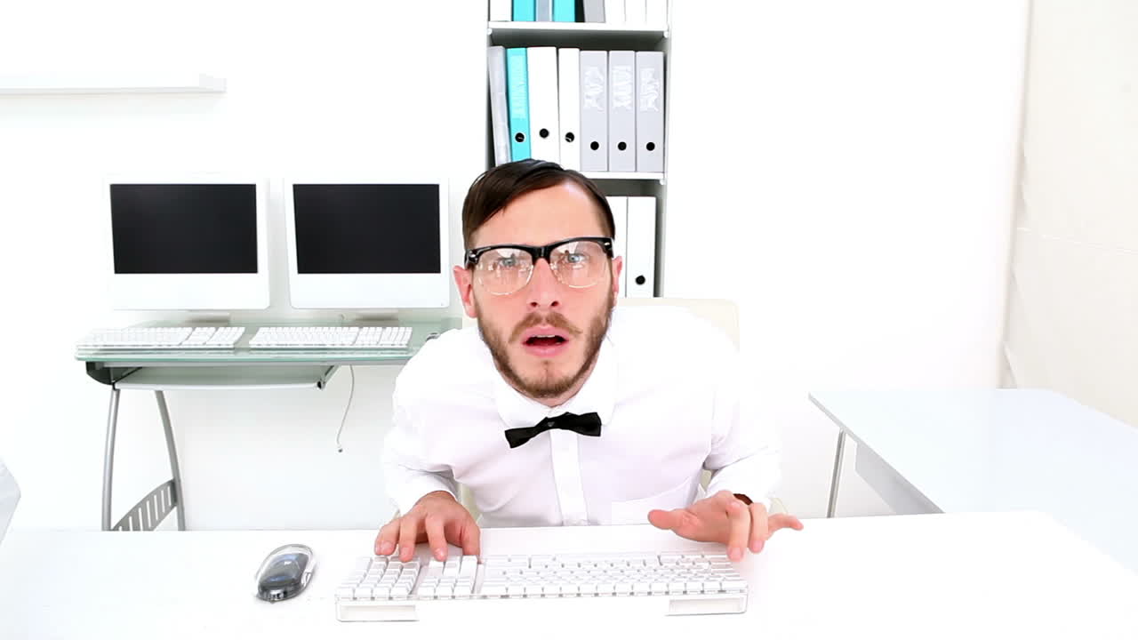 괴짜가 타이핑을 하고 책상에서 스트레스를 받습니다.