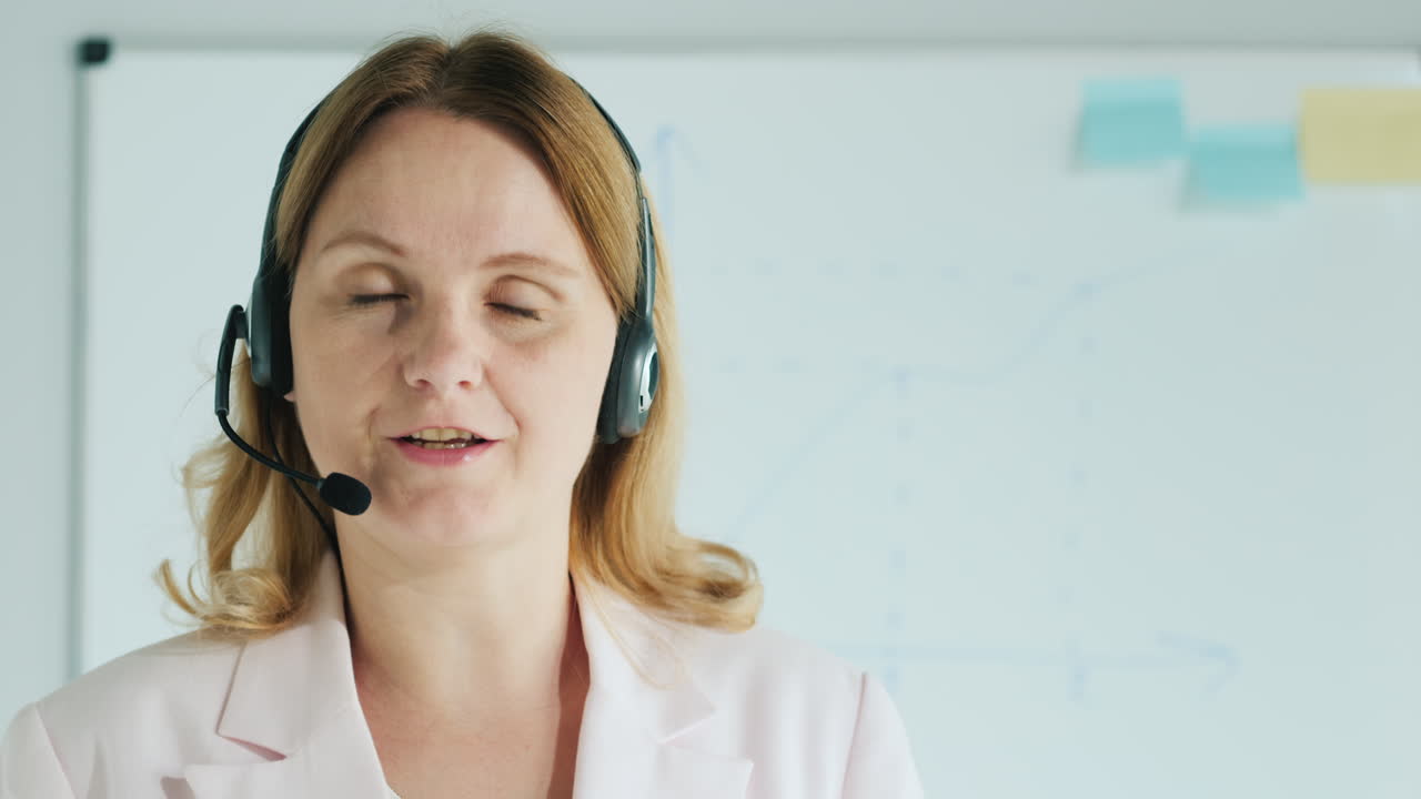 el entrenador de negocios en los auriculares habla sobre el fondo de la pizarra con horarios y diagramas