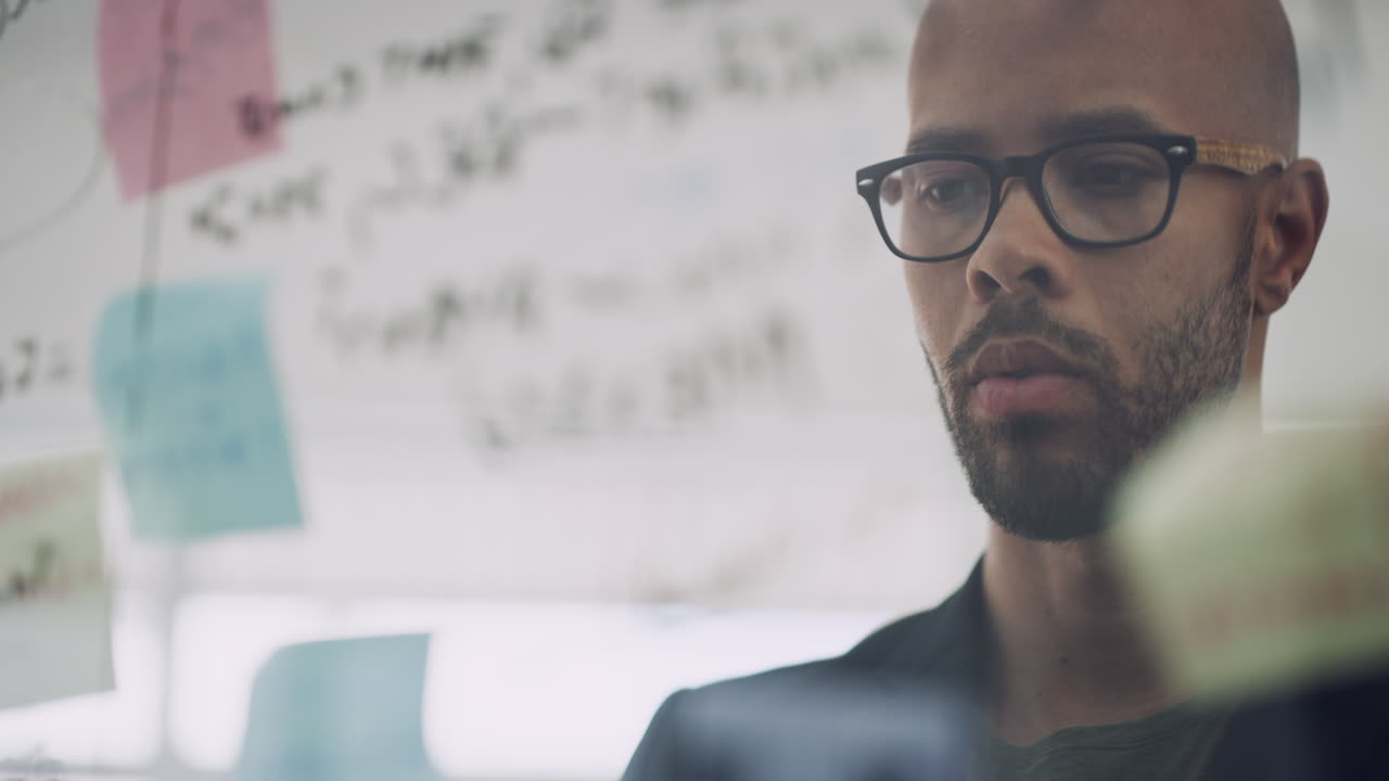 a businessman brainstorming with notes on a glass