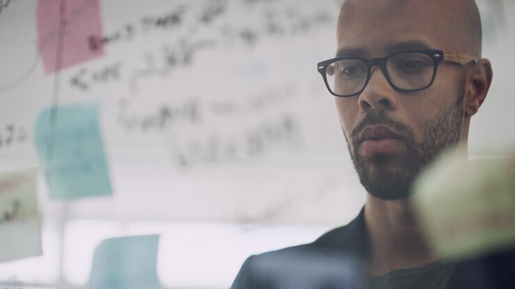a businessman brainstorming with notes on a glass