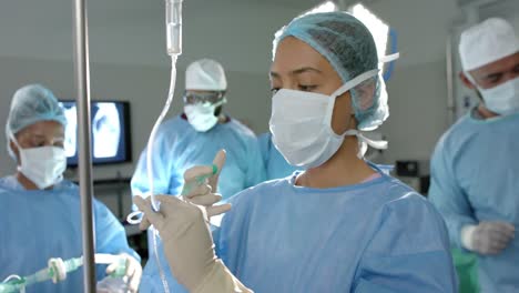 Biracial-female-surgeon-applying-drip-in-operating-theatre-at-hospital,-slow-motion