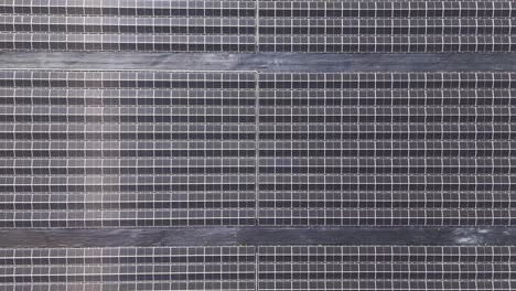 drone footage flying over a large solar farm with photovoltaic panels in a rural landscape, symbolizing renewable energy, sustainability, and climate change solutions for a greener future