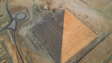 Aerial-perspective-unveils-the-awe-inspiring-Great-Pyramids-of-Giza-and-the-surrounding-Pyramids-Plateau-in-Egypt,-symbolizing-the-enduring-legacy-of-ancient-civilization-and-the-human-ingenuity