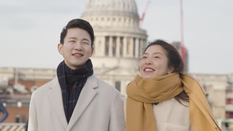 배경 4에서 세인트 폴 대성당과 밀레니엄 다리를 건너 휴일에 젊은 아시아 부부