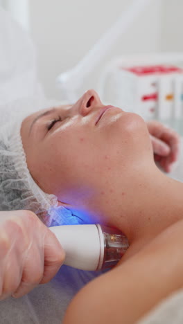 esteticista hace a la mujer rf lifting procedimiento de cosmetología de la cara y los ojos mascarilla de colágeno en el spa