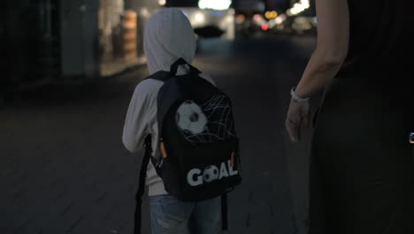 niño caminando con su madre y su juguete favorito