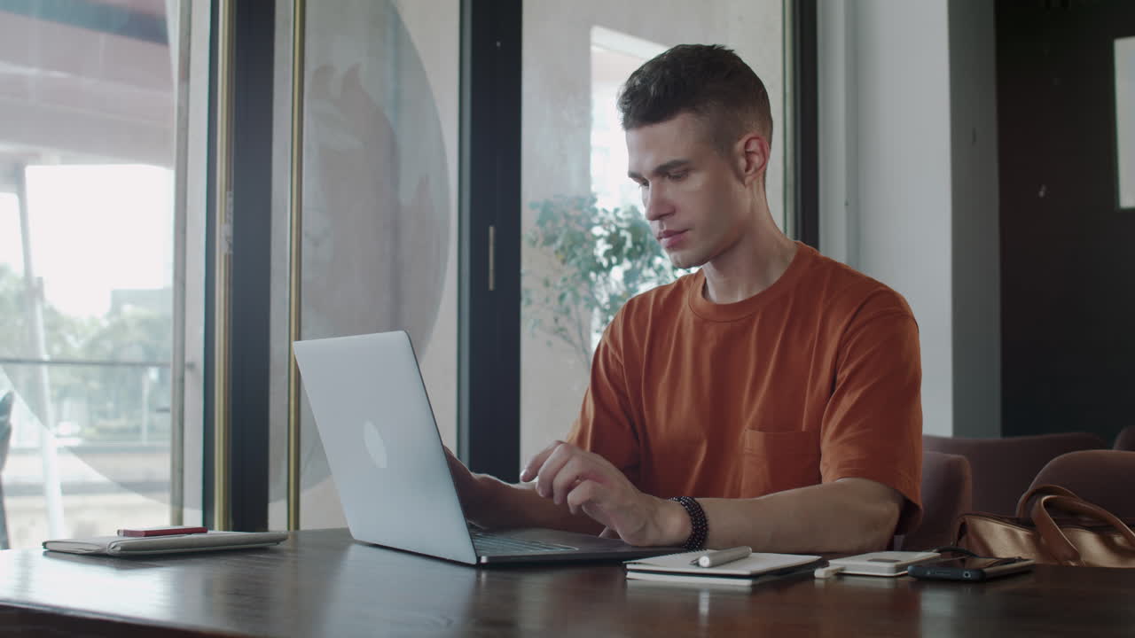 Young Businessman Analyzing Report on Laptop