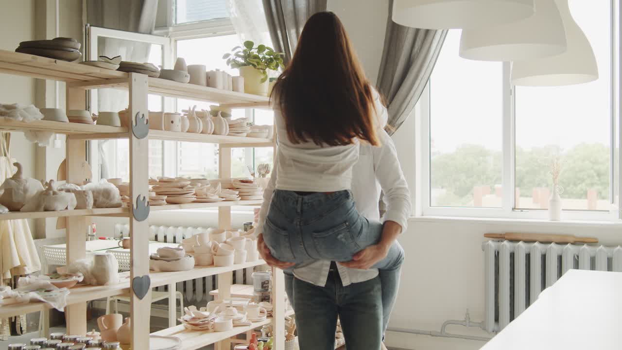 una pareja enamorada disfrutando de una cita romántica en un taller de cerámica.