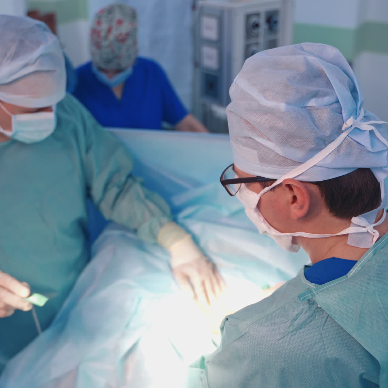 Top view of medical specialists at work. Professional doctors treating patient on the background of modern operating room.