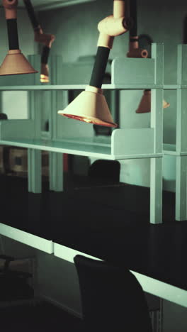espacio de trabajo de laboratorio vacío con mesa negra y estantes bajo luces