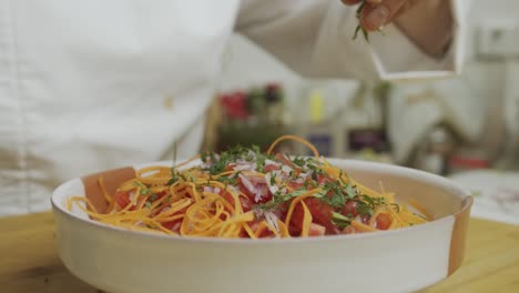 el chef agrega menta en rodajas encima de la ensalada de verduras