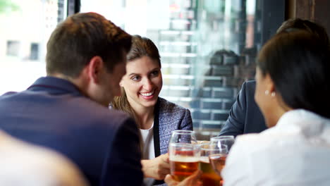 group of business colleagues meeting for drinks and socializing in bar after work