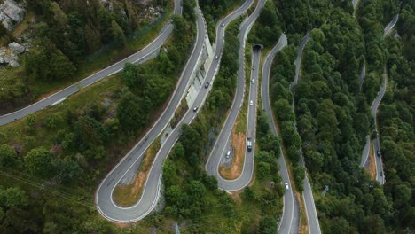 aerial drone above the scenic mountain serpentine road paluzza plöckenpass in italy by the natural austrian alps in summer with green forest trees in nature and travel vacation cars on the street