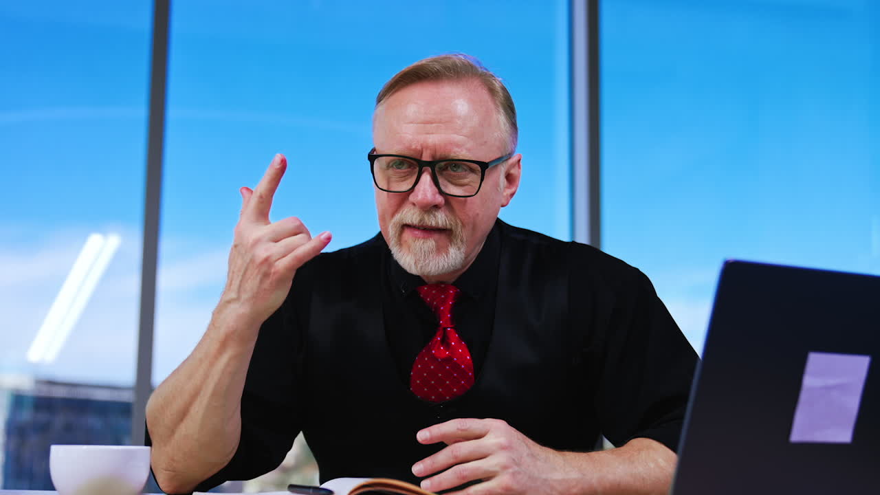 Focused Caucasian man sitting at desk looks aside and nods. Boss listens to his employees nodding approvingly.