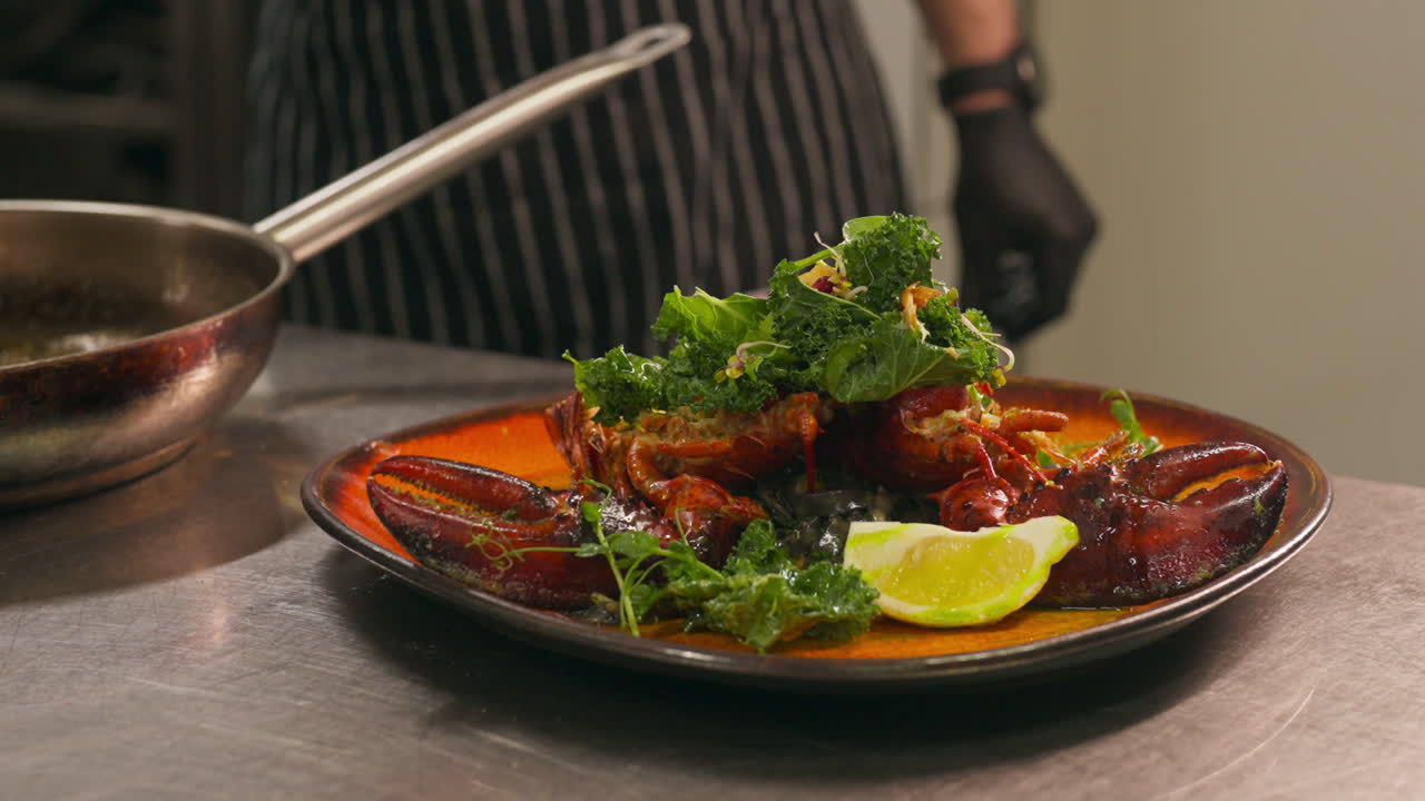 Chef Pouring Olive Oil Onto Lobster Dish In Plate. closeup shot